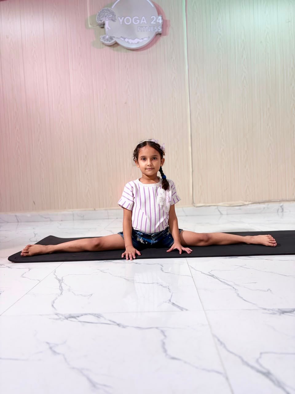 Young student holding a full front split in advanced yoga training