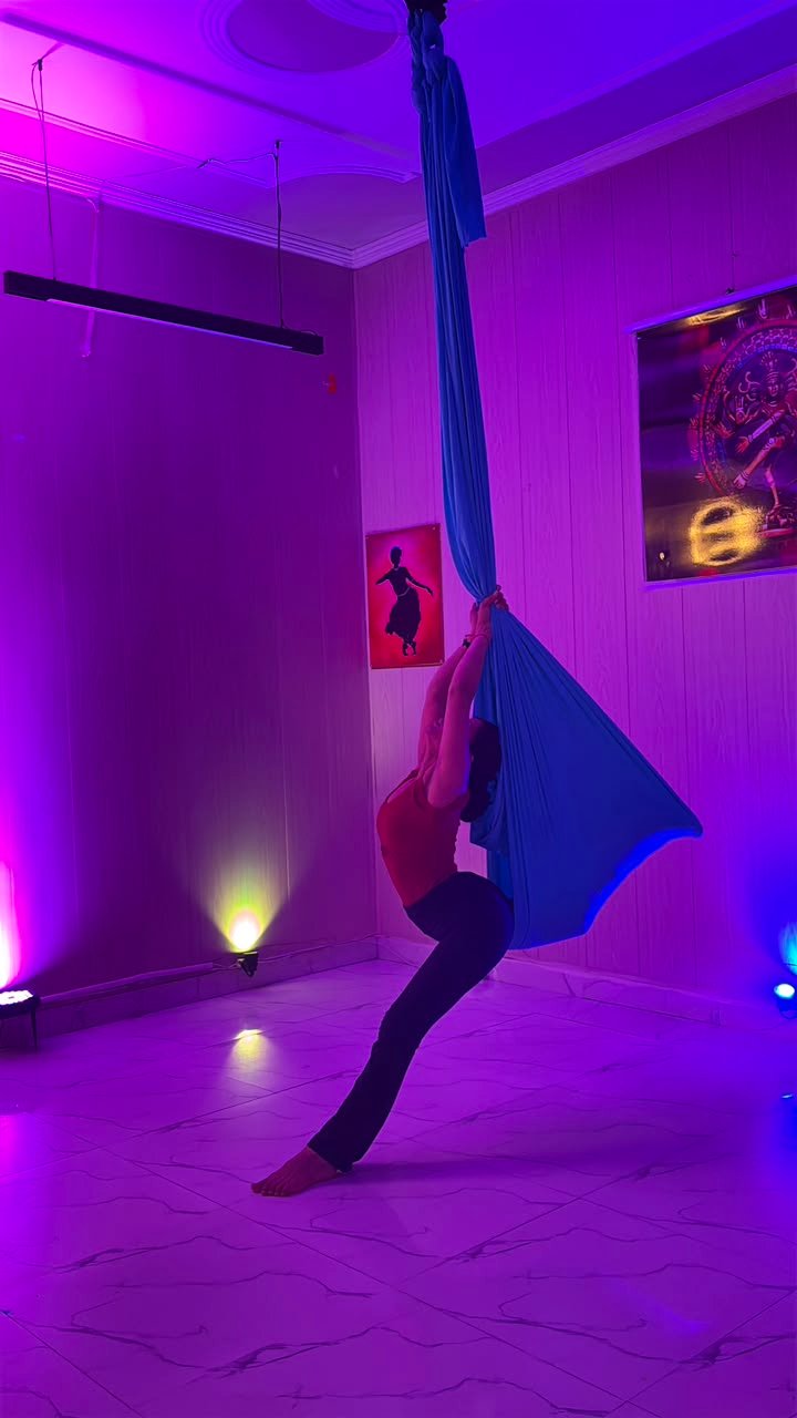 Aerial yoga student inverted in a silk hammock at Yoga24Fitness