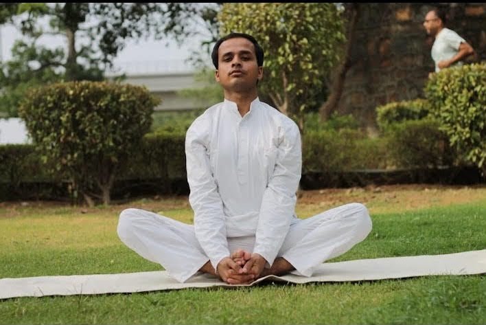 Yoga24Fitness trainer seated in lotus pose meditating outdoors