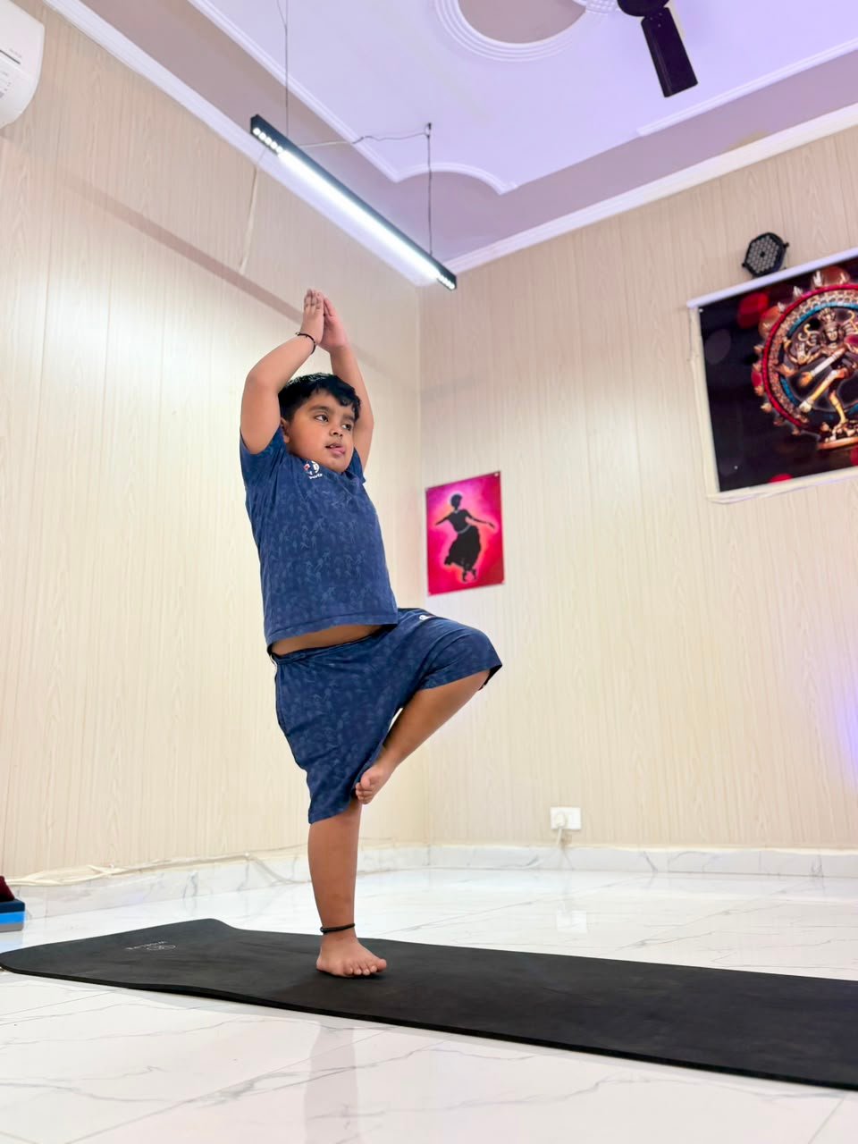 Student balancing in tree pose during a yoga class